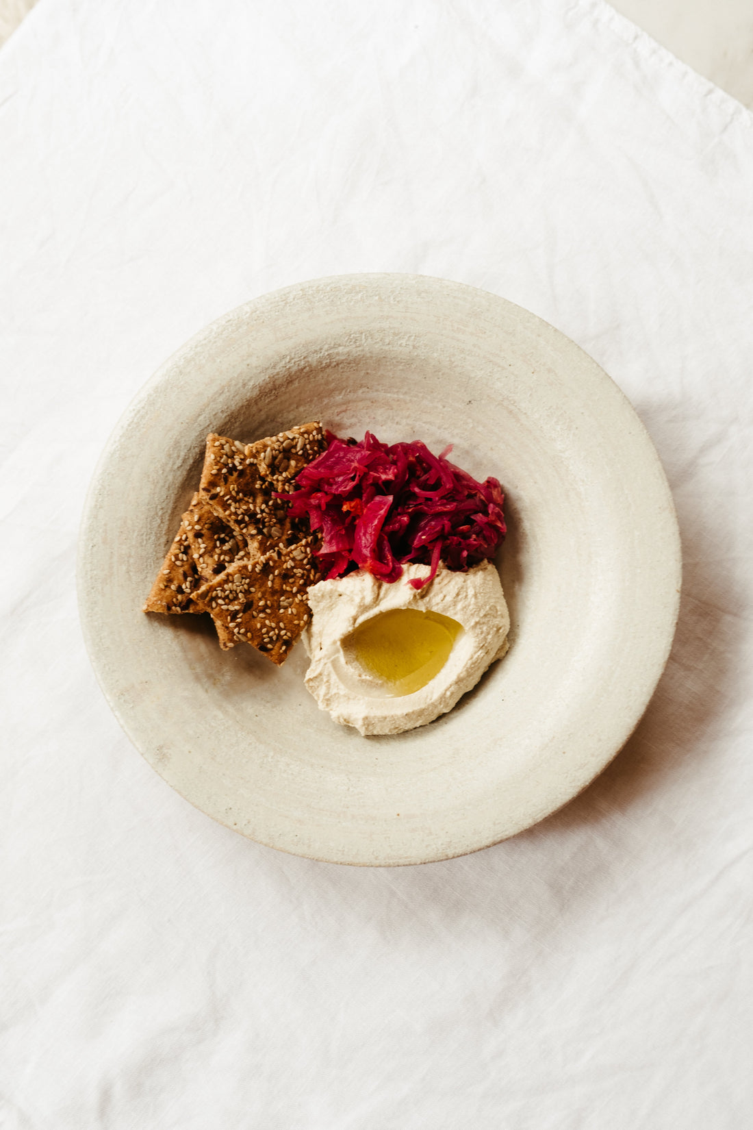  Tofu whip with Fermary Crisp Clean Pink Kimchi and Citizens of Soil olive oil on a ceramic plate with seeded crackers 
